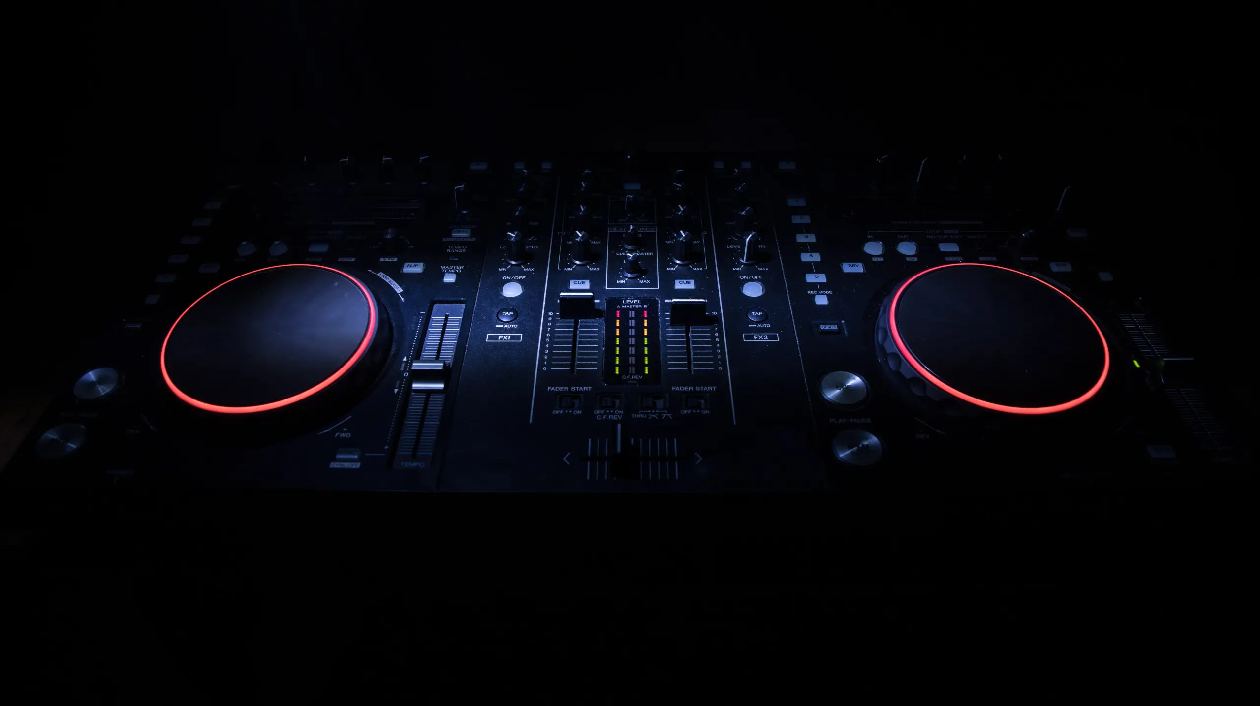 Close-up of a DJ mixer with illuminated controls